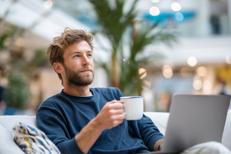 Finance expert with coffee cup in coworking space, laptop with spreadsheets, relaxed setting, Make smarter strategic financial decisions, Scaling your company