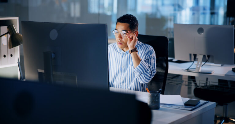 Reading, research and computer with business man in office for profit margin report, financial indicator