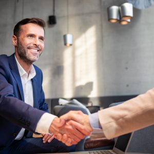 Negotiation skills, Business people shaking hands during meeting in cafe