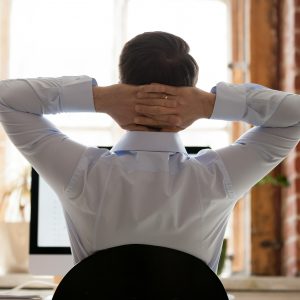 Relaxing businessman stretching with hands behind head, take break, stop micromanaging