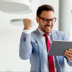 Portrait of young businessman with digital tablet in office looking on his own business master systems