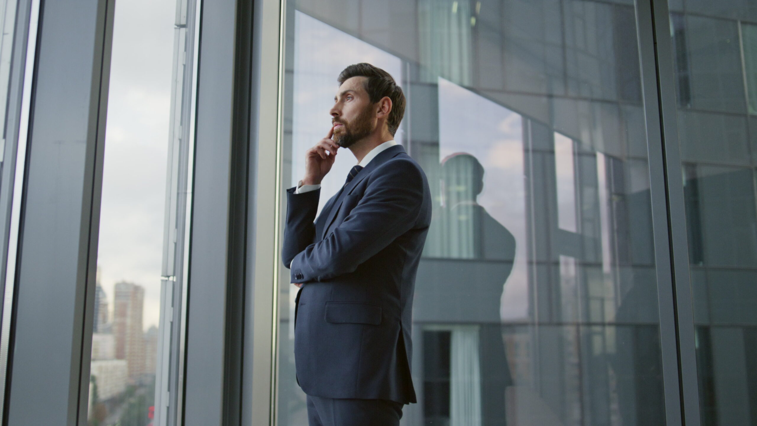 Serious smart entrepreneur lost in thoughts searching problem solution new ideas standing at office window, businessman pondering on important decision, Your hesitation is costing you your business