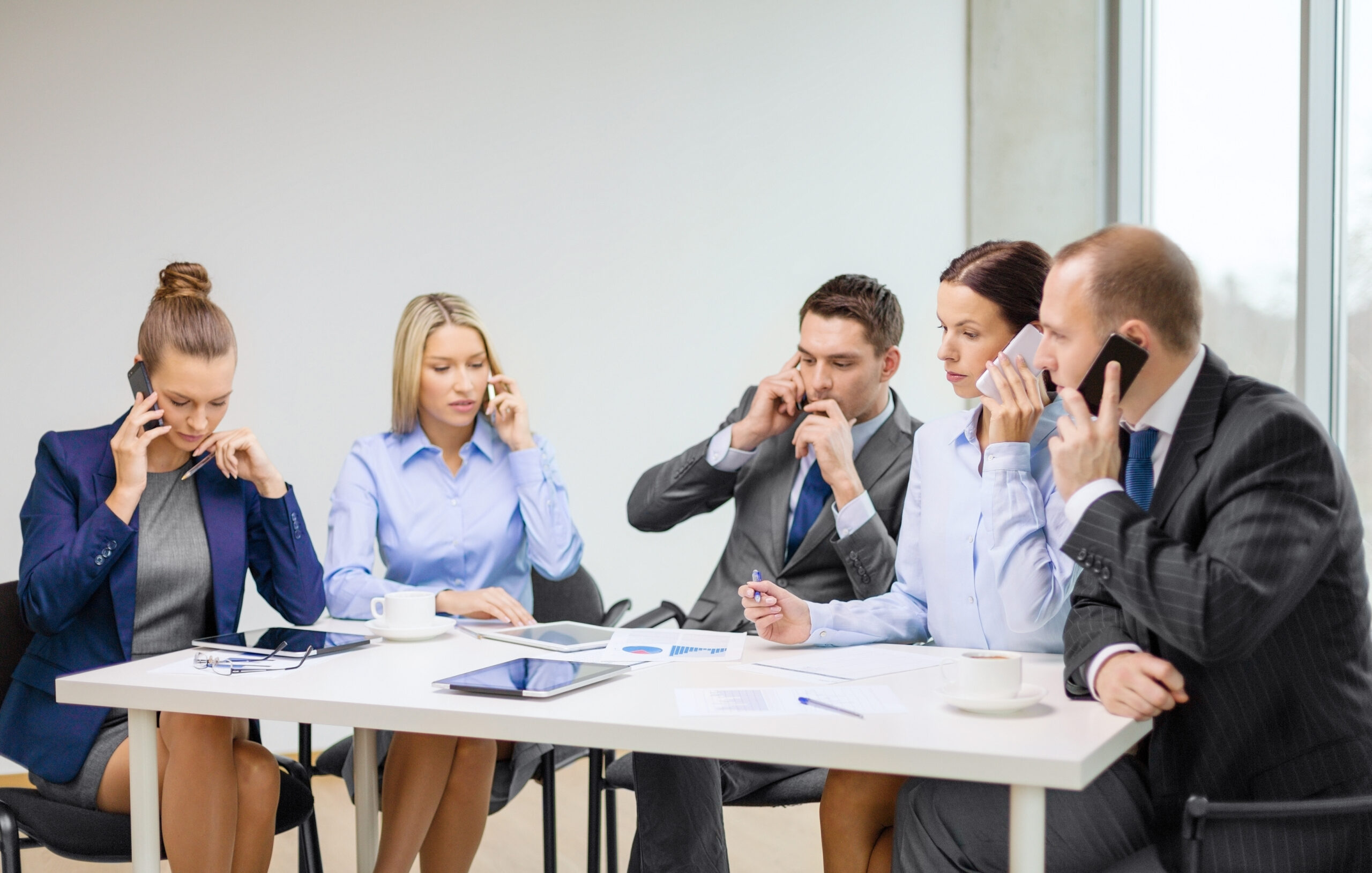 business, technology and office concept - business team with smartphones having conversation, to look more professional turn off your phone