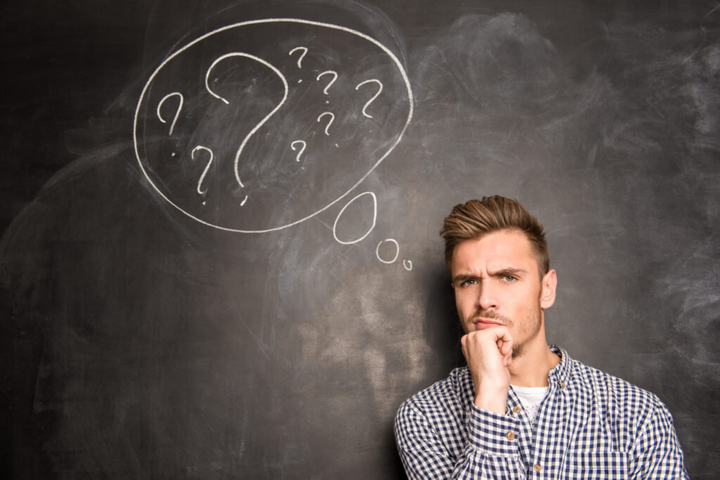 The 1 Question Every Business Owner Should Ask When Faced With a Tough Decision, Young man against the background of chalkboard thinking about the problem