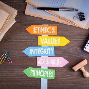 code of ethics concept. Paper signpost on a wooden desk