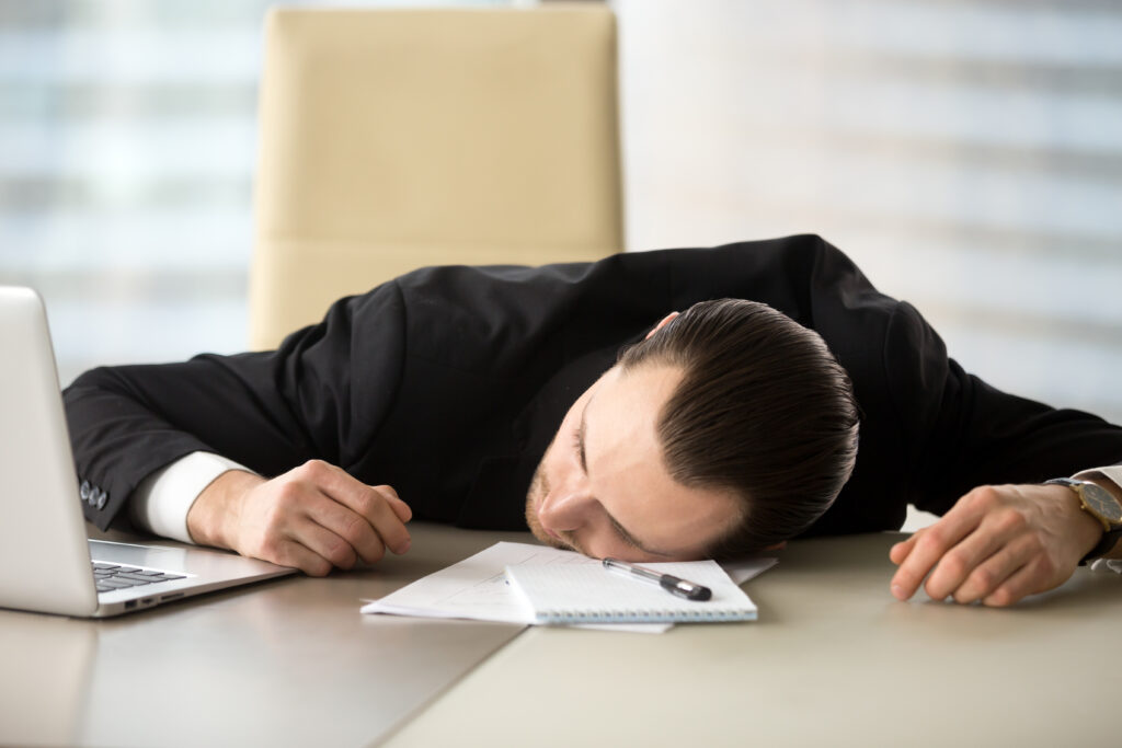 Exhausted businessman, Tired entrepreneur laying on his desk in front of laptop, Entrepreneurship is one of the loneliest professions