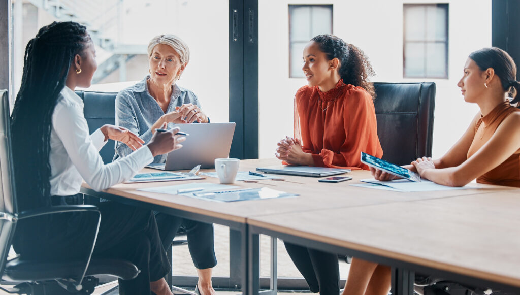 Office, boardroom and business women in meeting for teamwork, collaboration and planning. Corporate workers, diversity and people with laptop for project review, feedback, asking better questions and discussion with manager