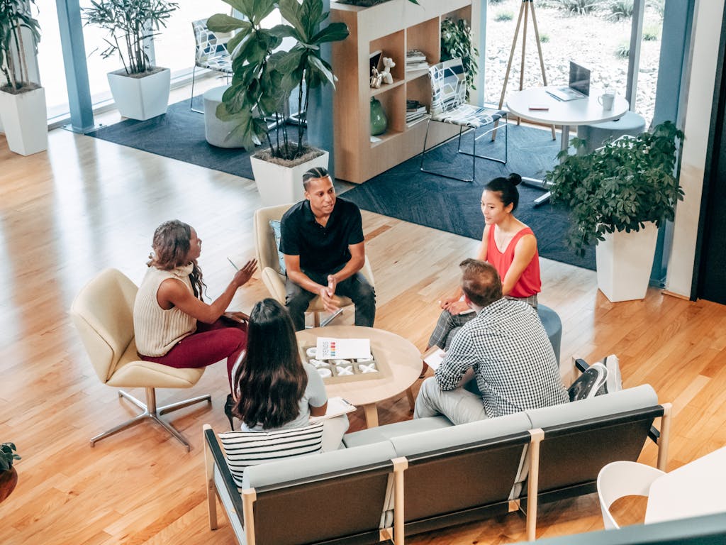 A diverse group of professionals engage in a collaborative team meeting in a stylish office environment.