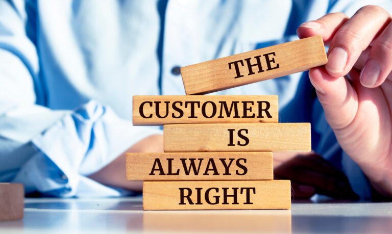Close up on businessman holding a wooden block with "The Customer is Always Right" message, Think twice about the "Customer Always Being Right"